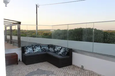 a couch with pillows sitting on a balcony at Beach Front Apartment 2 in Sagres