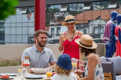 a group of people sitting around a table eating at Drapes Design Apartments by An Island Apart in Funchal