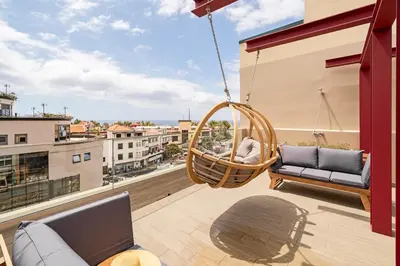 a swing on a balcony with a view of a city at Drapes Design Apartments by An Island Apart in Funchal