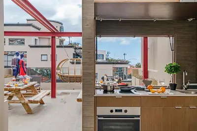 a kitchen and living room with a view of a balcony at Drapes Design Apartments by An Island Apart in Funchal