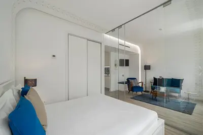 a white bedroom with a bed and a desk at Drapes Design Apartments by An Island Apart in Funchal