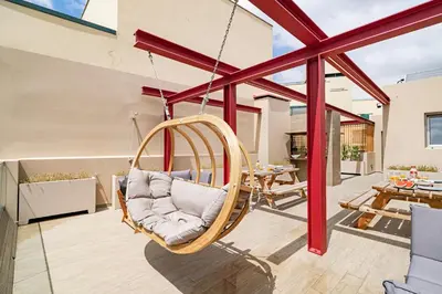 a hanging chair in a living room with a patio at Drapes Design Apartments by An Island Apart in Funchal