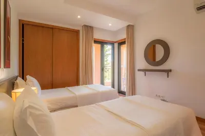 a balcony with two chairs and a view of trees at Luz casas- BayLuz apart,pool,beach, tennis, wifi,aircon in Luz