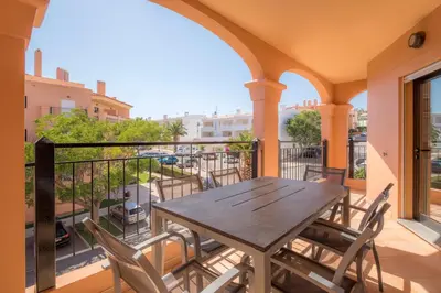 a patio with a table and chairs on a balcony at Luz casas- BayLuz apart,pool,beach, tennis, wifi,aircon in Luz