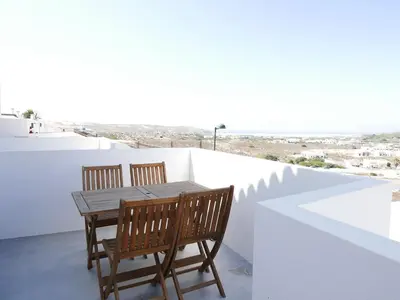 a wooden table and two chairs on a balcony at Casa na Carrapateira, Aljezur in Carrapateira