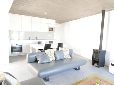 a living room with a blue couch and a kitchen at Casa na Carrapateira, Aljezur in Carrapateira