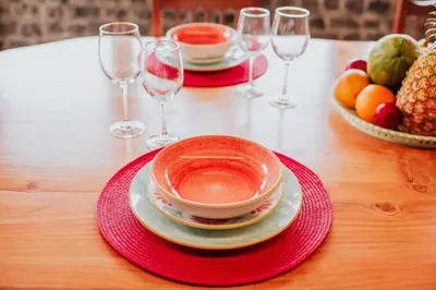 a table with a cup and plates and wine glasses at Casa da Morena by Amazing Madeira in Santa Cruz