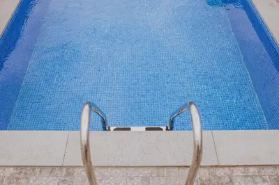 a swimming pool with two metal chairs next to it at Casa da Morena by Amazing Madeira in Santa Cruz
