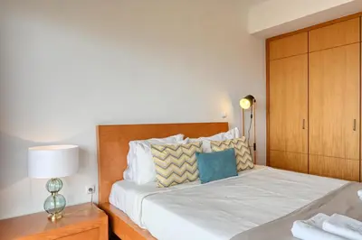 a bedroom with a large bed with a wooden headboard at Levada dos Piornais, a Home in Madeira in Funchal