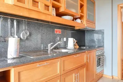 a kitchen with wooden cabinets and a sink at Levada dos Piornais, a Home in Madeira in Funchal