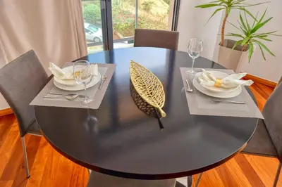 a black table with two plates and wine glasses on it at Levada dos Piornais, a Home in Madeira in Funchal