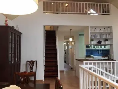 a living room with a staircase and a kitchen at GuestReady - Casa Avó Alice in Porto da Cruz