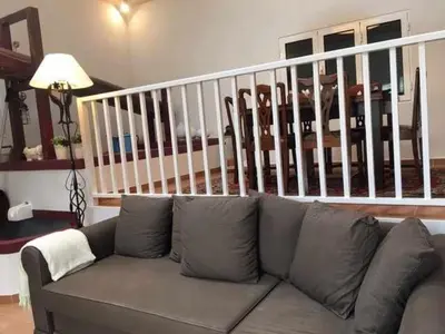 a couch in a living room with a staircase at GuestReady - Casa Avó Alice in Porto da Cruz