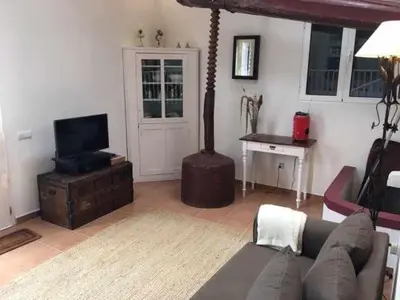 a living room with a couch and a television at GuestReady - Casa Avó Alice in Porto da Cruz