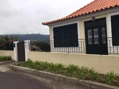 a house with a balcony with black shutters on it at GuestReady - Casa Avó Alice in Porto da Cruz