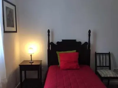 a bedroom with a red bed with a red pillow at GuestReady - Casa Avó Alice in Porto da Cruz