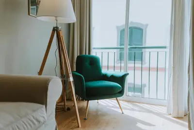 a living room with a green chair and a lamp at City Garden by Madeira Best Apartments in Funchal