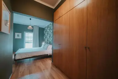 a bedroom with a bed and a large wooden cabinet at City Garden by Madeira Best Apartments in Funchal