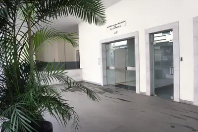 a palm tree in front of a building with elevators at City Garden by Madeira Best Apartments in Funchal