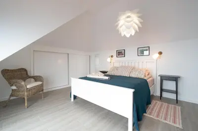 a bedroom with a bed and a chair at Seasky Arco in Arco da Calheta