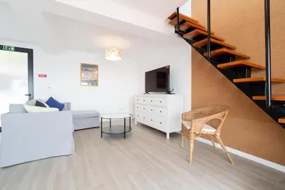 a living room with a couch and a staircase at Seasky Arco in Arco da Calheta