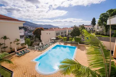 a balcony with a view of a swimming pool at FLH Funchal Modern Apartment with Pool in Funchal