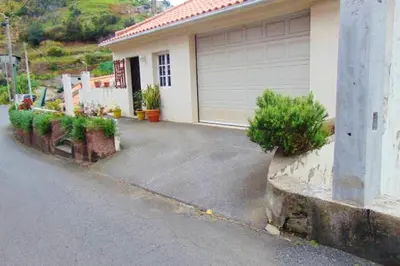 a house with a parking lot with a garage at Charming house in Machico with mountain view and garden in Machico