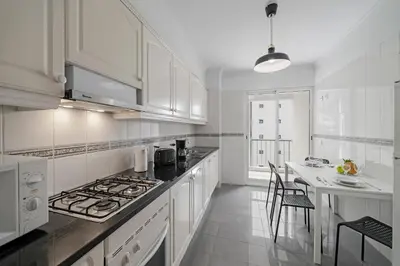a kitchen with white cabinets and a stove top oven at Ilhéus IV by An Island Apart in Funchal