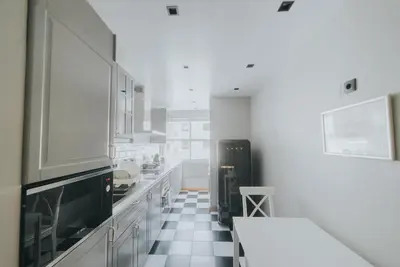 a kitchen with white cabinets and a black refrigerator at Cliff by Madeira Best Apartments in Funchal