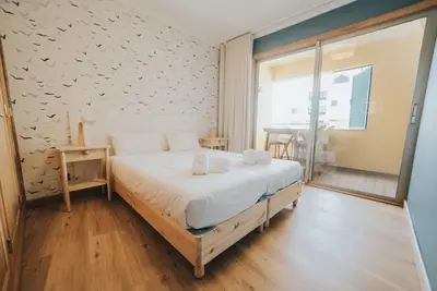 a bedroom with a bed with white sheets and a window at Cliff by Madeira Best Apartments in Funchal