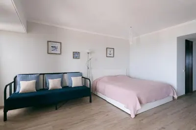 a bedroom with a bed and a blue couch at BINIS Apartment in Funchal