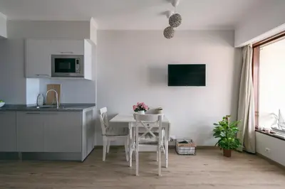 a white kitchen with a white table and chairs at BINIS Apartment in Funchal