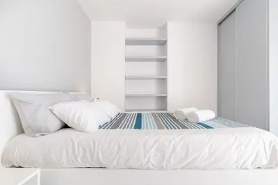a bed with white sheets and pillows on it at Casa Campos , Modern two bedroom house in Loreto in Achada de Cima