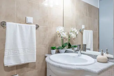 a bathroom with a sink and a toilet and towels at Casa Campos , Modern two bedroom house in Loreto in Achada de Cima