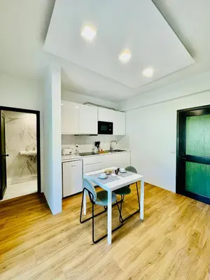 a white kitchen with a table and a counter at VALE MAR Guest in Ribeira Brava
