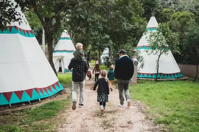 a group of people walking down a path with tents at Salema Eco Camp - Sustainable Camping & Glamping in Salema