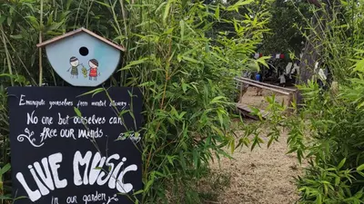 a sign in a bush with a bird house on it at Salema Eco Camp - Sustainable Camping & Glamping in Salema