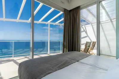 a bedroom with a bed and a large window at Escarpa - The Madeira Hideaway in Ponta do Sol
