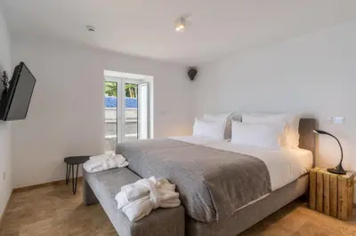 a bedroom with a large bed and a window at Escarpa - The Madeira Hideaway in Ponta do Sol