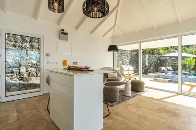 a kitchen with a counter and a living room at Escarpa - The Madeira Hideaway in Ponta do Sol