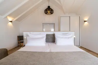 a bedroom with a white bed with white pillows at Escarpa - The Madeira Hideaway in Ponta do Sol