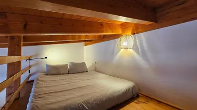 a bed in a room with a wooden ceiling at Sea View Apartment Carrapateira in Carrapateira