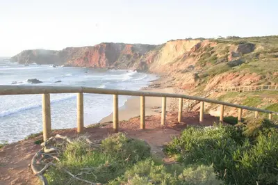 a view of a beach with a fence and the ocean at Sea View Apartment Carrapateira in Carrapateira