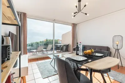 a kitchen and living room with a table and chairs at Costa Apartment - Vista Mar in Caniço