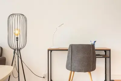 a desk with a chair and a lamp at Costa Apartment - Vista Mar in Caniço