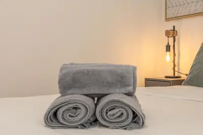 a pile of towels sitting on top of a bed at Costa Apartment - Vista Mar in Caniço