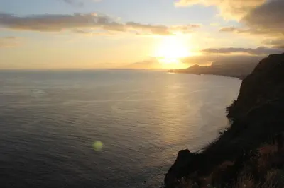 a sunset over the ocean with the sun setting at CRISTO REI APARTMENT in Caniço