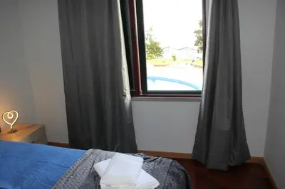 a bedroom with a bed and a large window at CRISTO REI APARTMENT in Caniço