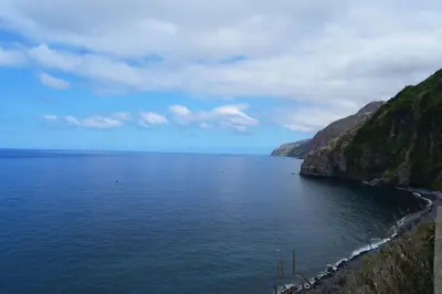 a large body of water next to a cliff at Casa dos Anjos in Ponta do Sol