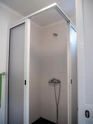 a shower with a glass door in a bathroom at Casa dos Anjos in Ponta do Sol